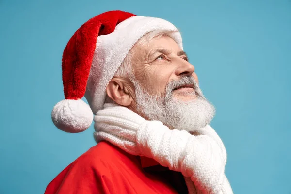 Side view of Santa Claus in hat and white scarf looking up