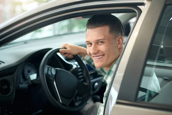 Hombre feliz en coche en la concesionaria . — Foto de Stock