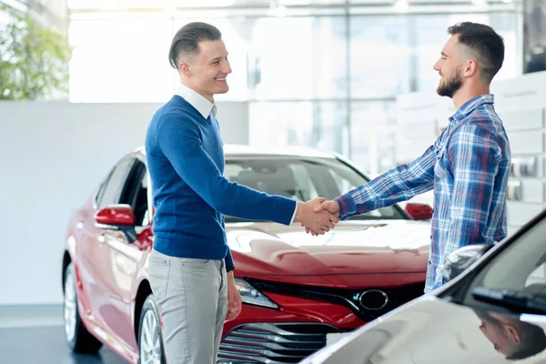 Carro vendedor e cliente aperto de mão na concessionária de carro . — Fotografia de Stock