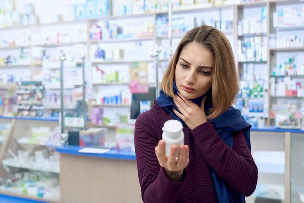 Mujer enferma leyendo instrucciones sobre pastillas en la farmacia . — Foto de Stock