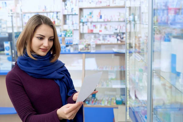 Giovane donna che legge prescrizione in farmacia . — Foto Stock