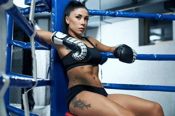 Mujer kickboxer descansando en la esquina del anillo . — Foto de Stock