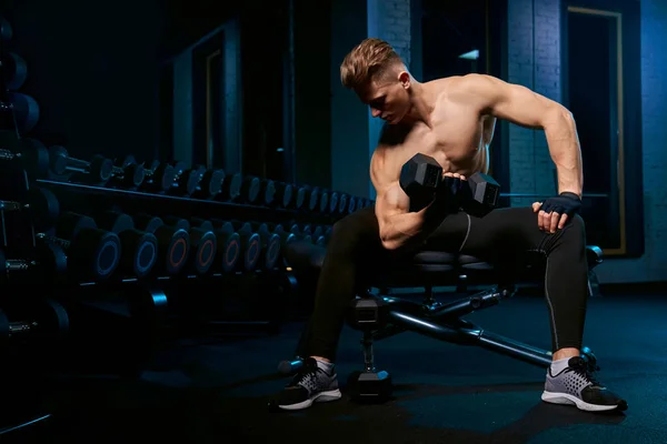 Muskulös idrottsman bygga biceps med hantel. — Stockfoto
