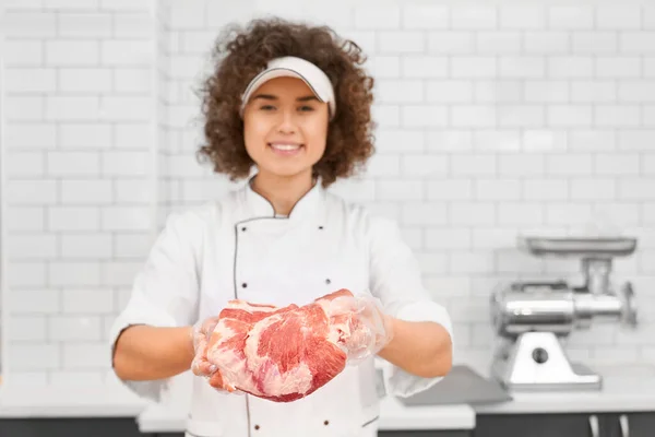 Macellaio donna che dimostra carne al supermercato. — Foto Stock