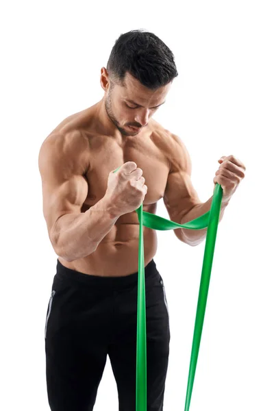 Bodybuilder training arms with resistance band. — Stock Photo, Image