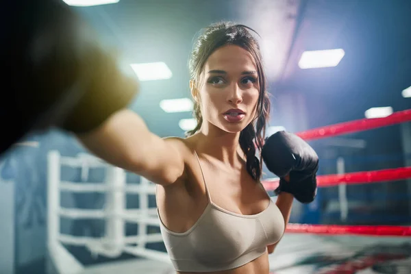 Female boxer showing hit in boxing gloves. — Stock Photo, Image