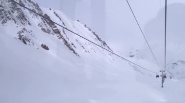 Gondol karlı kış dağlarında yükseliyor..