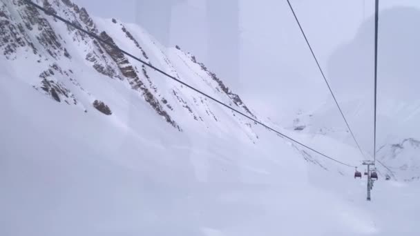 Gondole soulevant à travers les montagnes enneigées d'hiver. — Video