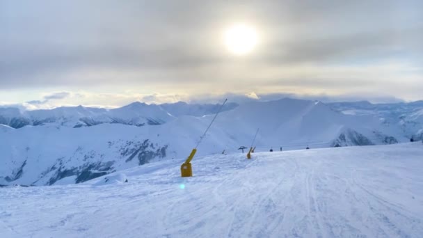 Movimiento distante de las pistas de esquí en la ladera nevada . — Vídeos de Stock