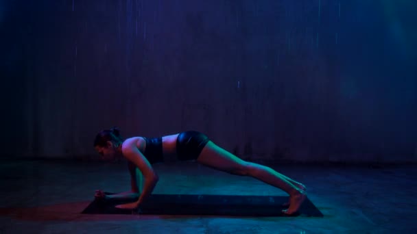 Woman training arms in plank position, rain. — Stock Video