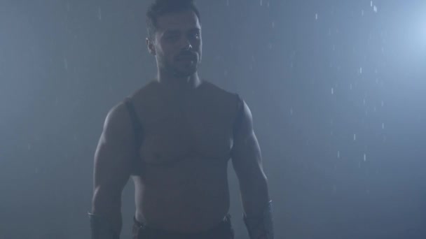 Spartan warrior posing under rain. — Stock Video