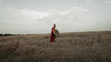 Kuru alanda poz veren kırmızı pelerinli Spartalı..