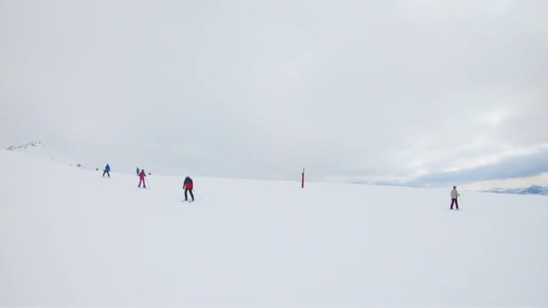 Narciarze jadący ze śnieżnego wzgórza. — Wideo stockowe