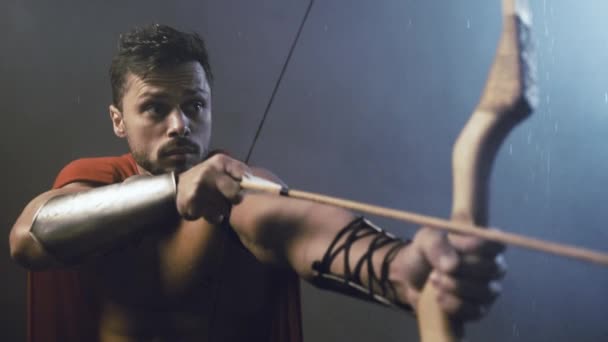 Wet spartan raising bow with arrow. — Stock Video