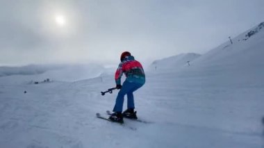 Kayakçı kayak merkezinde yamaçta geziyor..