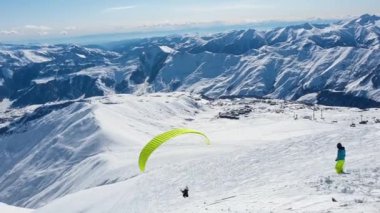 Paraşüt uçağı karlı dağların üzerinde uçar.