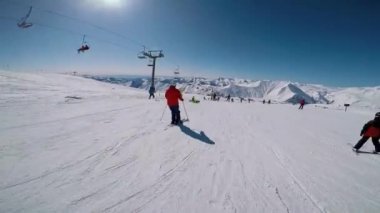 Kayakçı elinde kamerayla yamaçta geziyor..