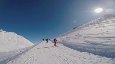 Dağlarda yamaçlarda gezen kayakçılar.