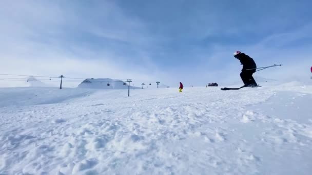 Moedige skiërs rijden vanaf een besneeuwde heuvel. — Stockvideo