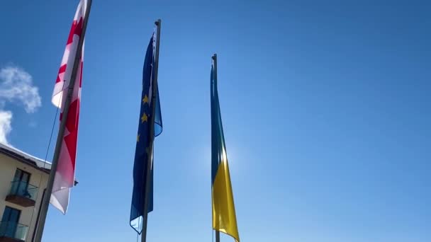 Tres banderas ondeando contra el cielo azul . — Vídeos de Stock