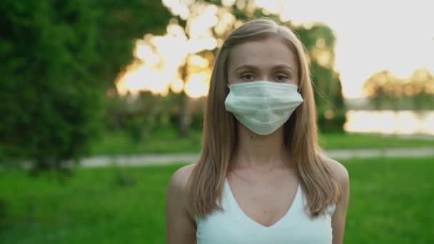 Woman taking off face mask outdoors. — Stock Video