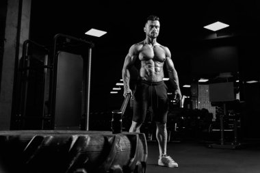 Spor salonunda elinde balyoz tutan kaslı adam..