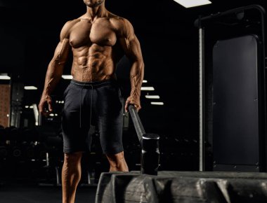 Balyoz tutan adale kaslı adam.