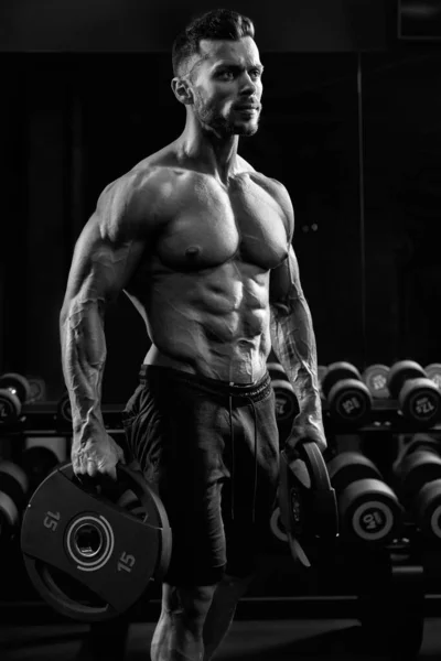 Tensad manlig kroppsbyggare som håller vikter. — Stockfoto