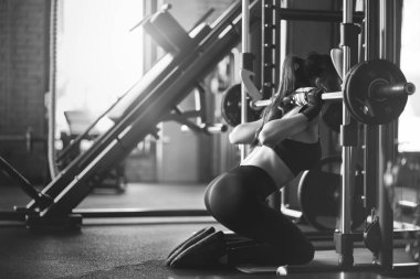 Sportsoman dizlerinin üstüne çömeliyor, tek renk..