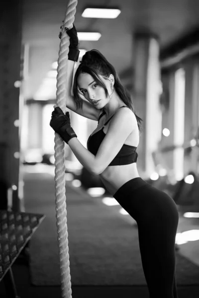 Wanita pas memegang tali di gym, monokrom. — Stok Foto