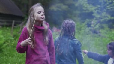 Kız kamp ateşinin yanında eğleniyor..