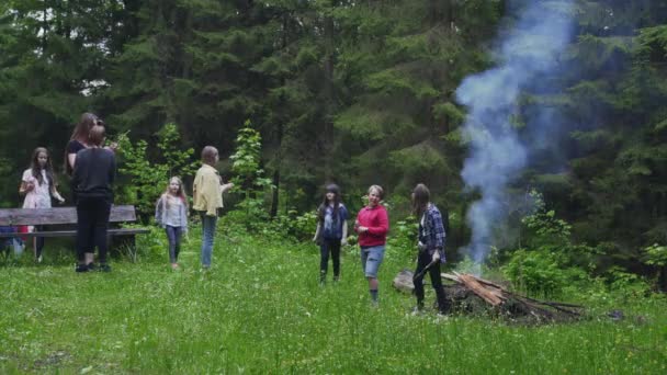 Tonåringar pratar nära lägerelden. — Stockvideo