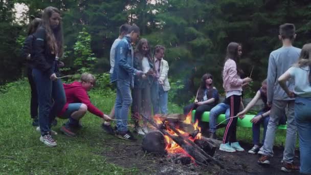 Tonåringar som leker ha kul nära lägerelden. — Stockvideo