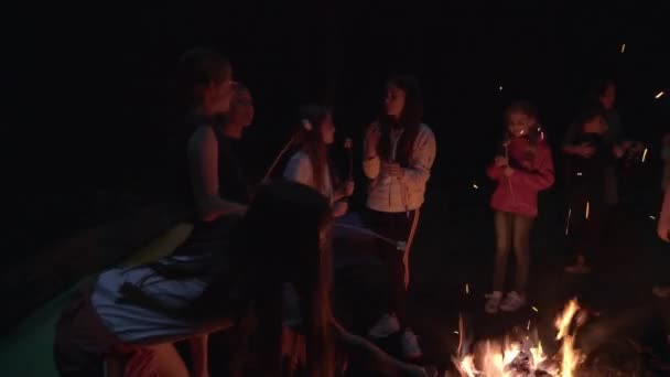 Teenky pečení marshmallows na táboráku. — Stock video