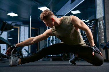 Vücut geliştirici spor salonunda vücudunun üst kısmını geriyor..