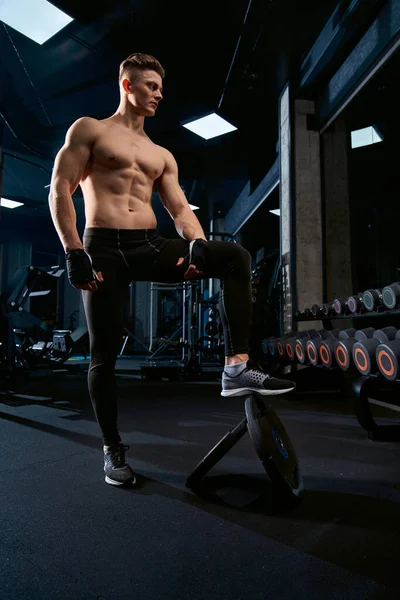 Skjortlös idrottsman poserar i gymmet. — Stockfoto