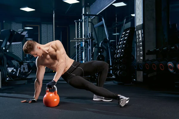 Bodybuilder gör sidoplank övning. — Stockfoto