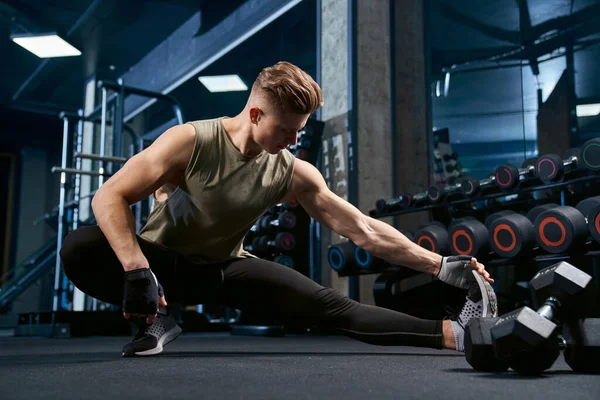 Bodybuilder stretching bovenlichaam in de sportschool. — Stockfoto