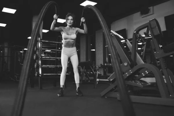 Monochromatyczny portret kobiety trenującej na siłowni. — Zdjęcie stockowe