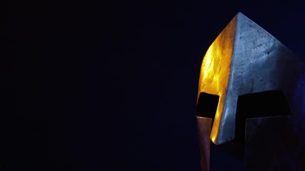 Eiserner spartanischer Helm isoliert in der Dunkelheit. — Stockvideo