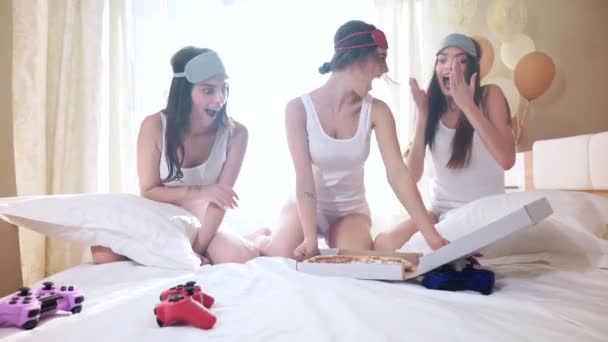 Chicas elegantes sentadas en la cama y comiendo pizza . — Vídeos de Stock