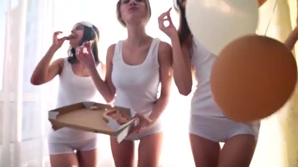Χαριτωμένα κορίτσια χορεύουν στην κρεβατοκάμαρα και τρώνε πίτσα.. — Αρχείο Βίντεο