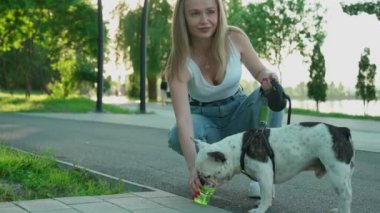 Parktaki köpeğe su veren genç bir kadın..