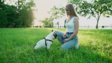 Genç bayan köpek sahibi dışarıda buldog eğitiyor..
