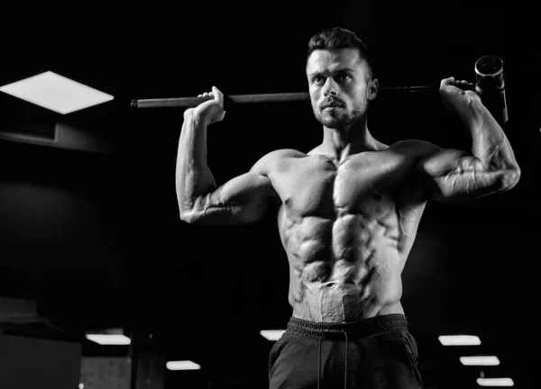 Muskuløs skjorteløs mann med slegge i gymsalen. – stockfoto