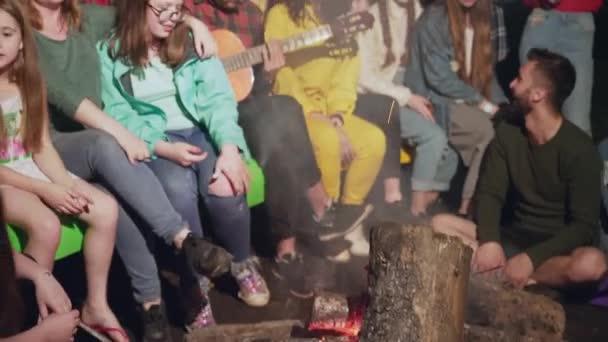 Kids singing and playing guitar near camp fire. — Stock Video