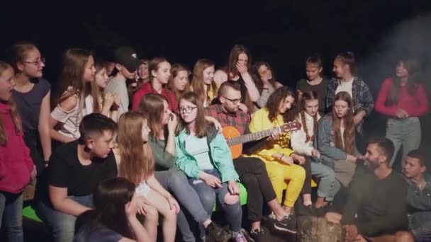 Děti zpívají u táboráku. — Stock video