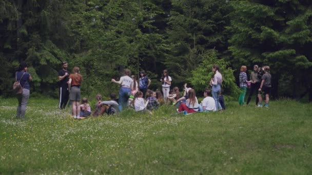 Adolescentes sentados en esteras en el bosque. — Vídeo de stock