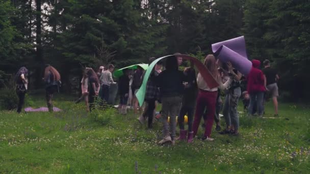 Adolescentes que usan esteras como paraguas en el bosque. — Vídeo de stock