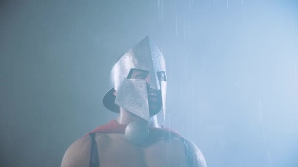 Laughing spartan looking at raindrops on blade. — Stock Video